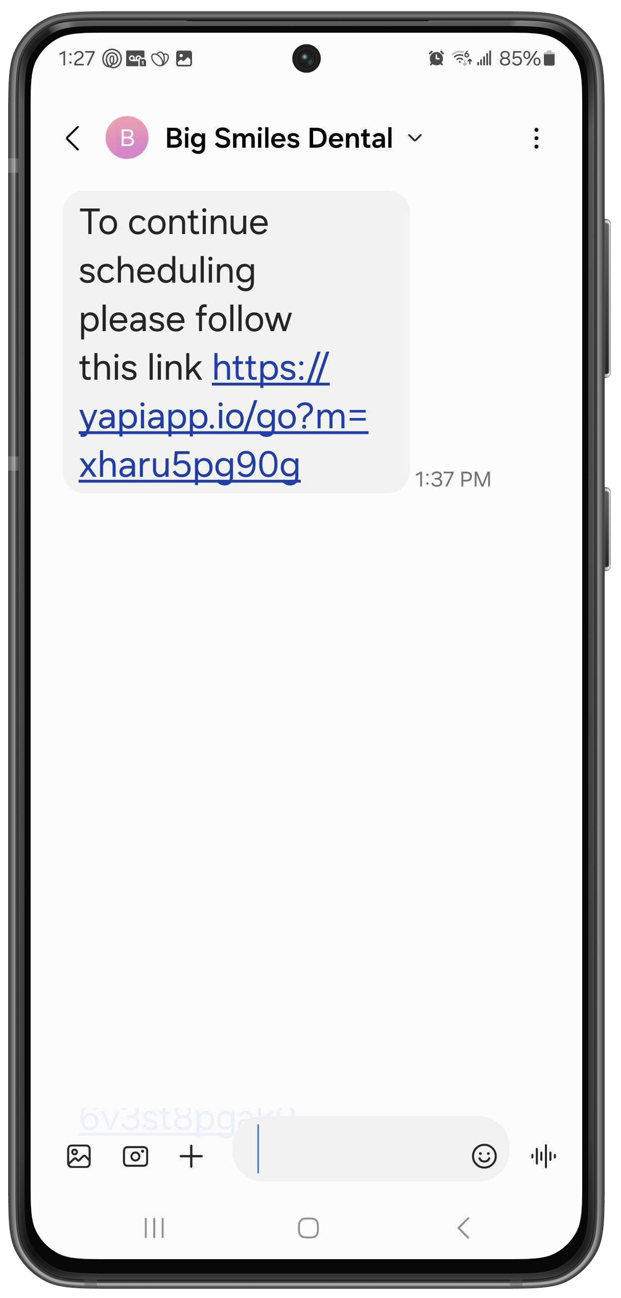 Phone showing a text that reads "To continue scheduling please follow the link" followed by a link to schedule an appointment.